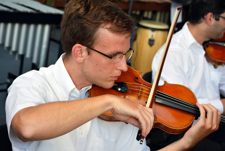 a man holding onto a violin while standing next to other men