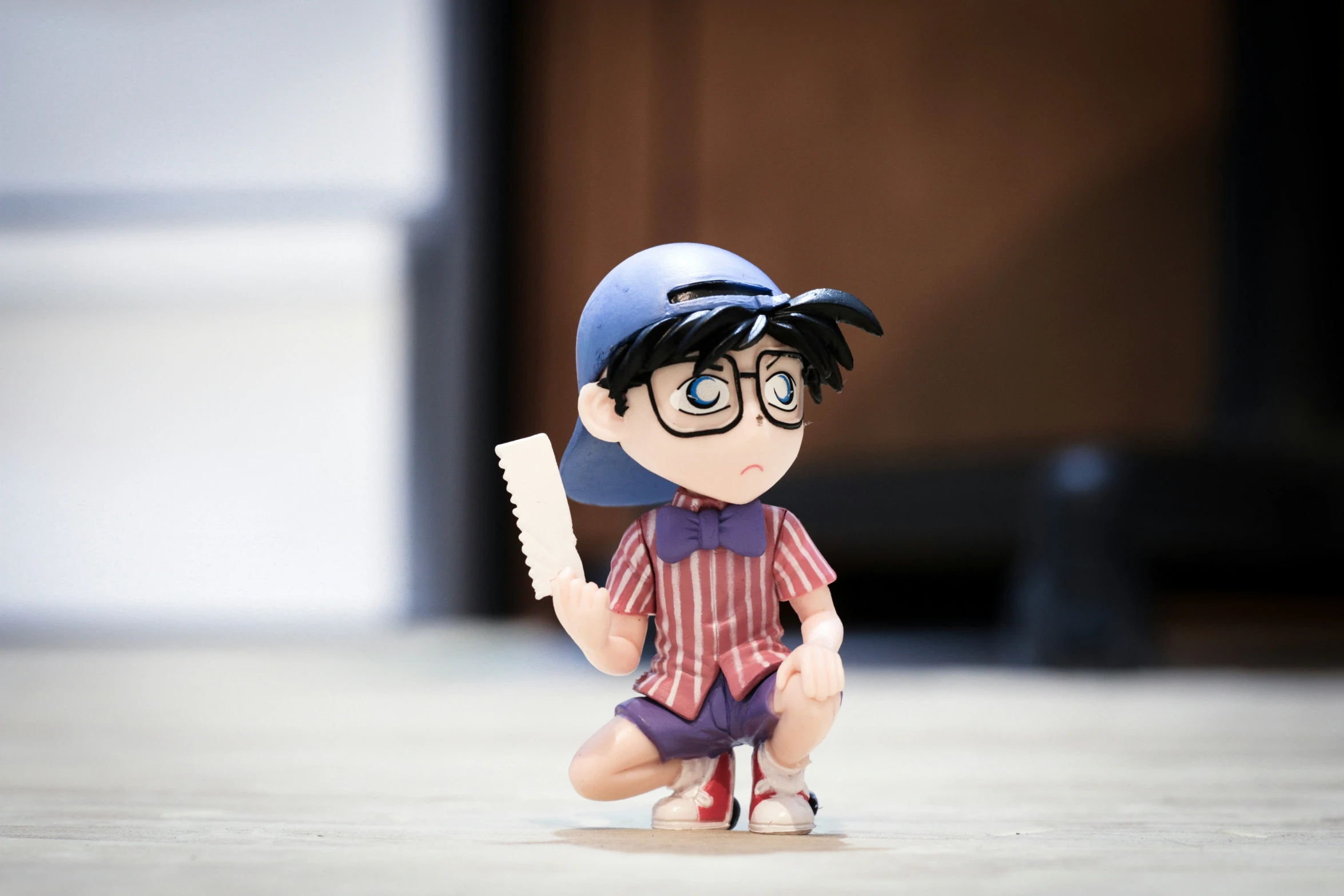 a cartoon bobble head figure with blue eyeglasses and hat