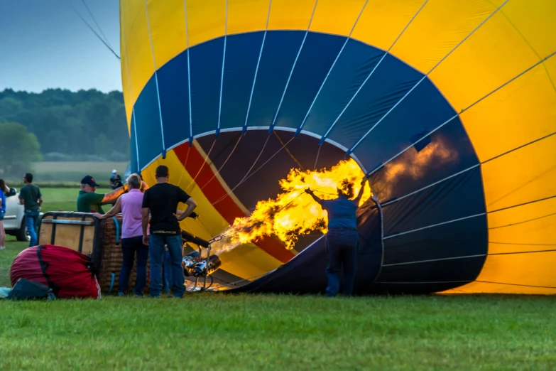 the people in the field are standing near a huge  air balloon