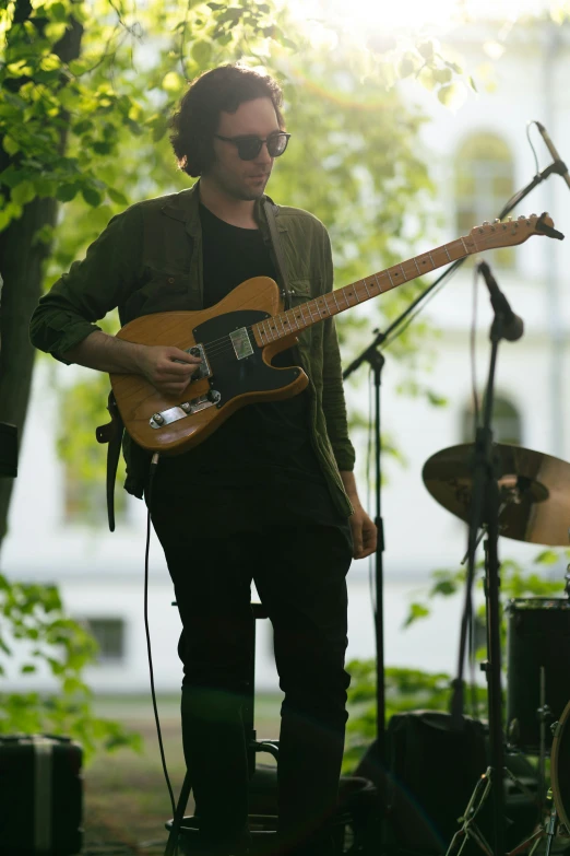 a man in sunglasses and glasses is playing the guitar