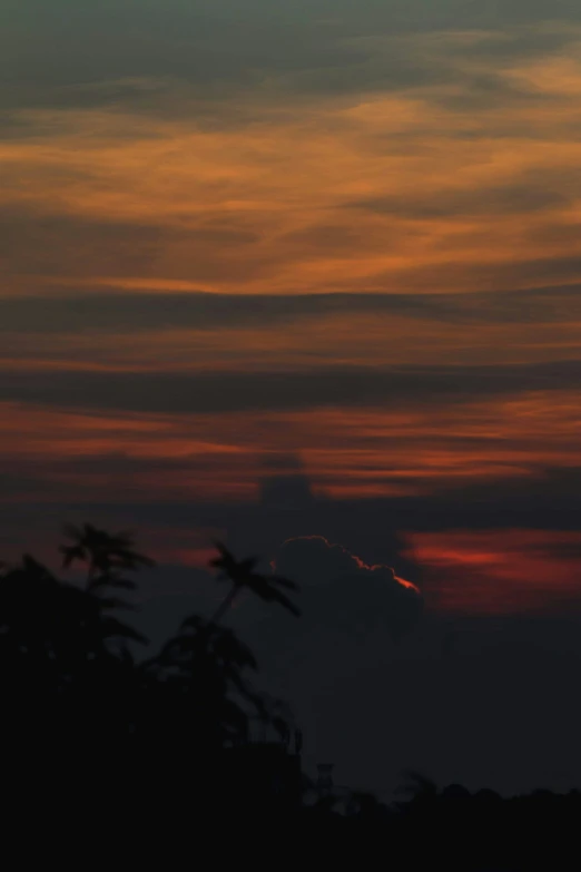 the sun is setting over the horizon in a dark sky