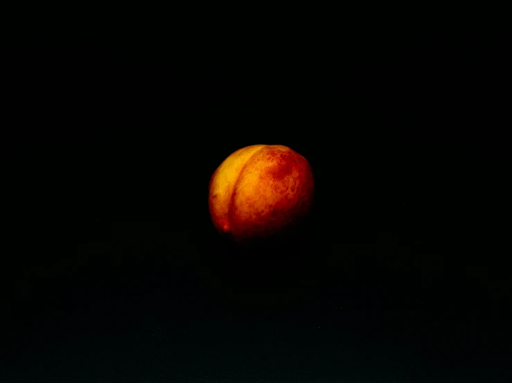 an apple is lit up on a black background