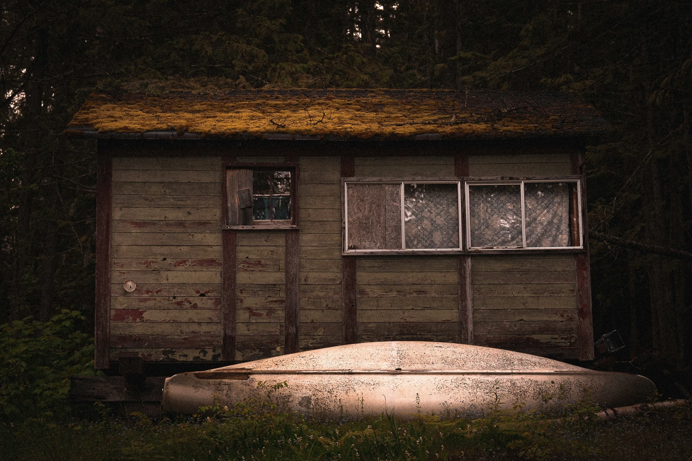 a boat sitting outside of a home at night