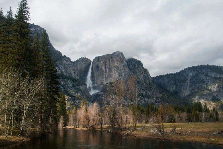 a mountain range surrounded by a river with a waterfall