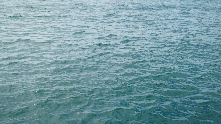 blue ocean water with a small boat in it