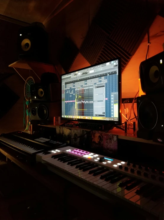 electronic keyboard sitting on the table in front of the monitor