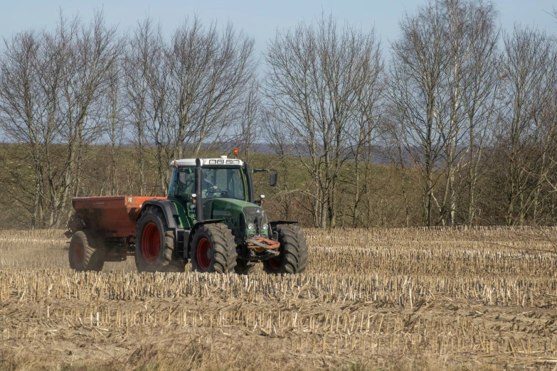 the tractor has plowing around a farm field