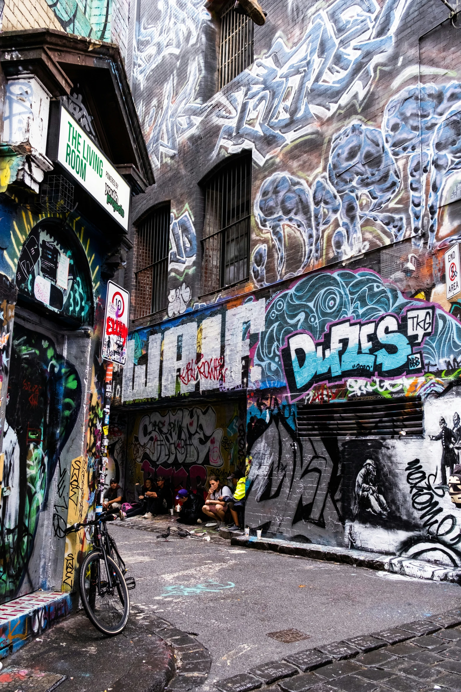 a wall covered with graffiti on the side of a road