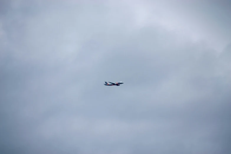 an airplane flying in the cloudy sky with a plane below it