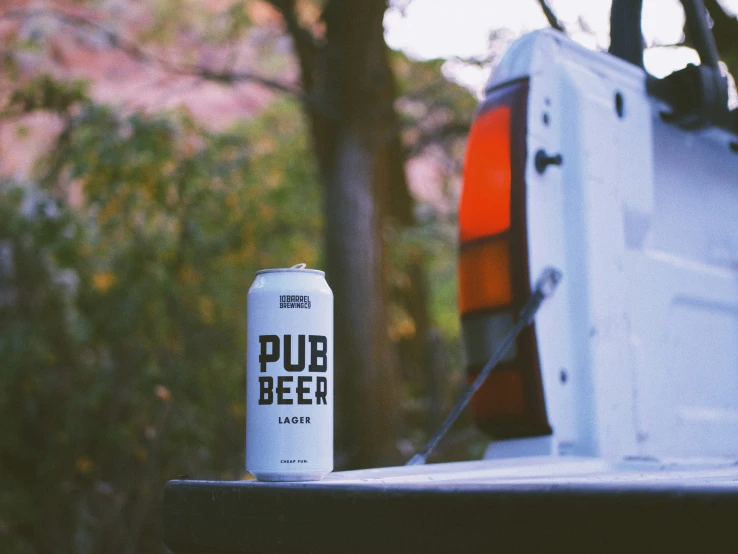 a white beer can next to a parked car