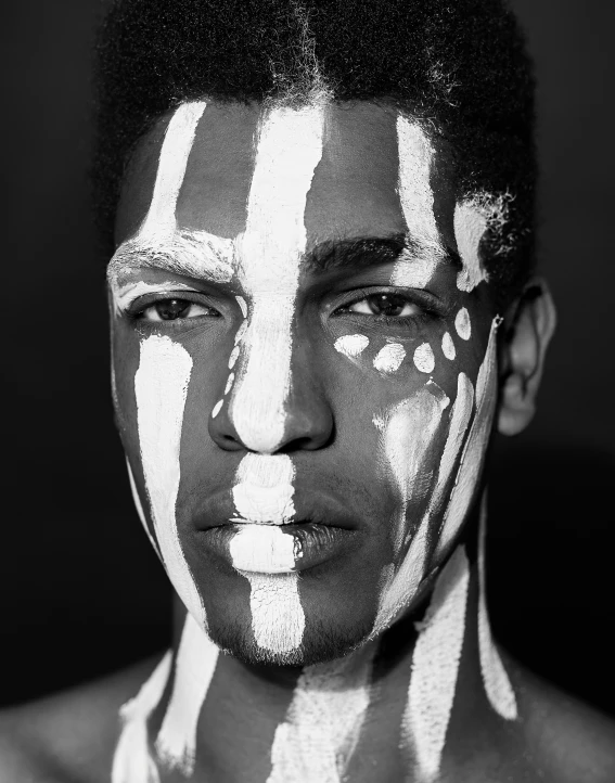 a black and white po of a man with some paint all over his face