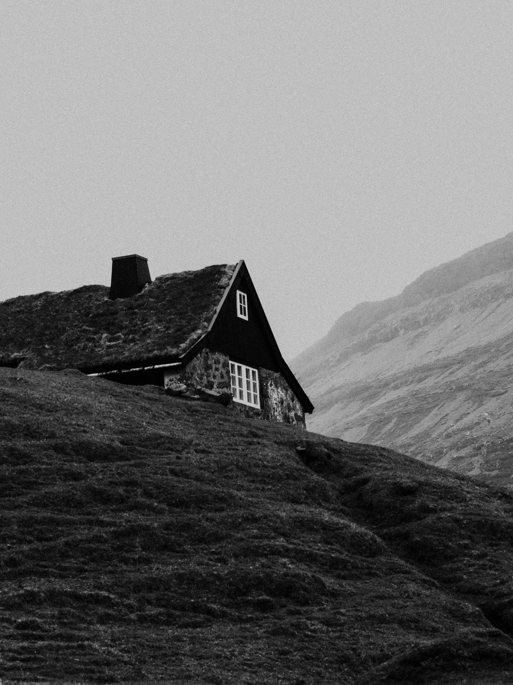 a black and white po of a house on the hill