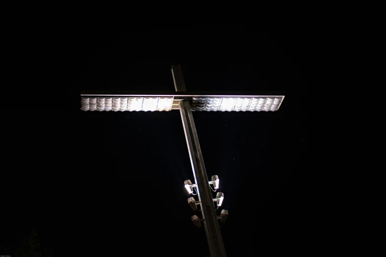 a streetlight in the dark with a telephone pole on top