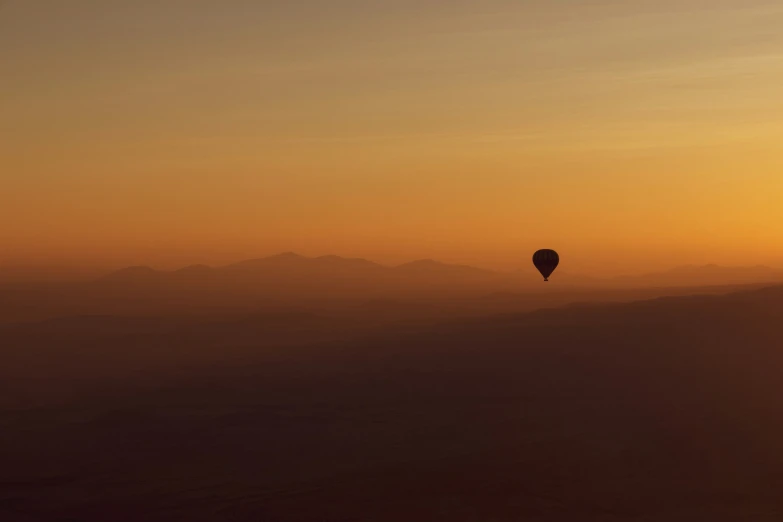 a  air balloon flying over the mountain tops