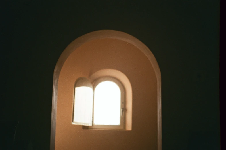 an arched archway in the wall with two windows