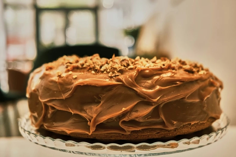 a frosted cake on a glass cake plate