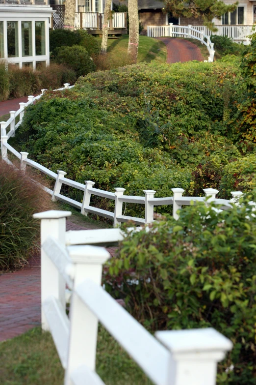 a white wooden fence is leading down the walkway