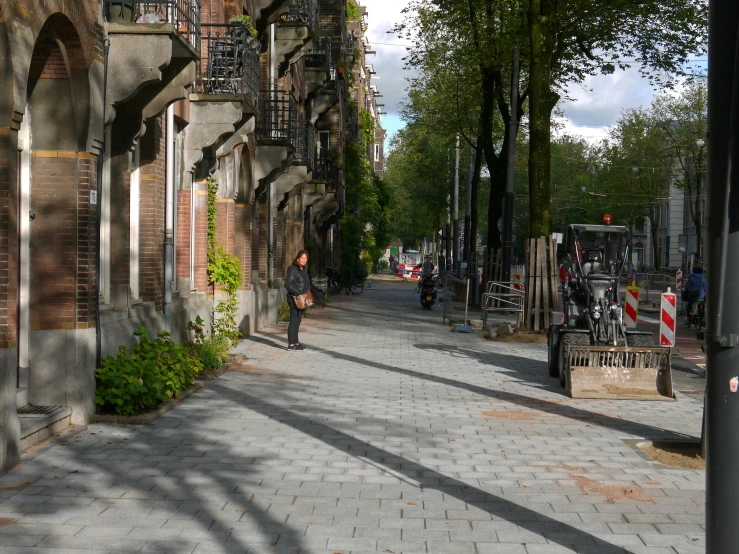 a man walking down a street past buildings