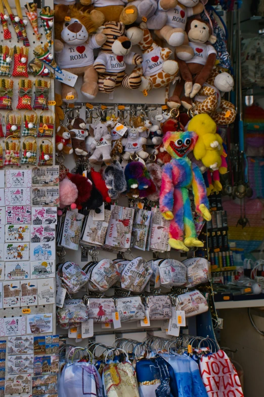 many stuffed animals hang from strings on the wall