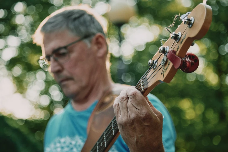 the man is playing the guitar on the grass