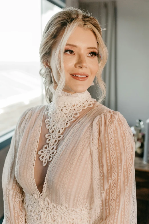 a woman smiling at the camera in front of a window