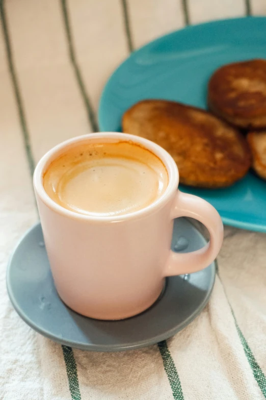 a small cup of coffee next to some small pastries