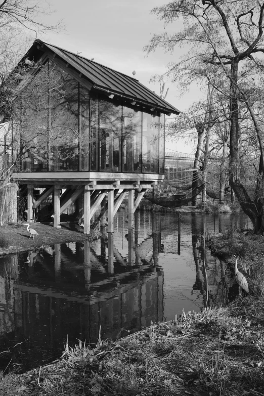 an old wooden building sits on the edge of a small lake