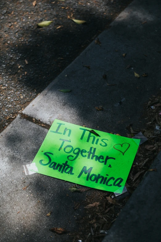 the sign is lying on the concrete on the sidewalk