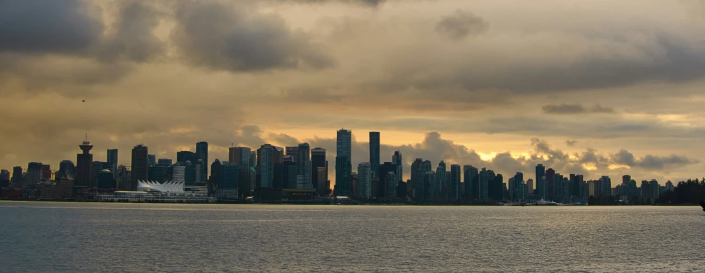 dark storm clouds loom over the city from the water