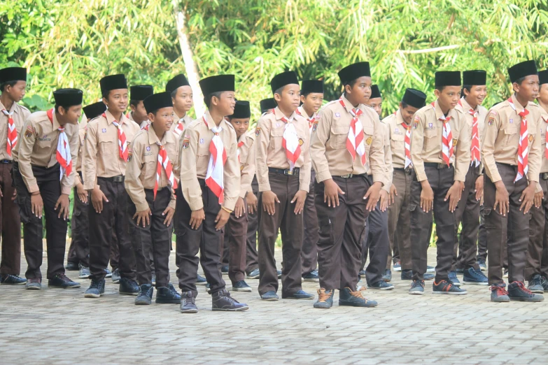 boys in uniforms are standing together with ties on