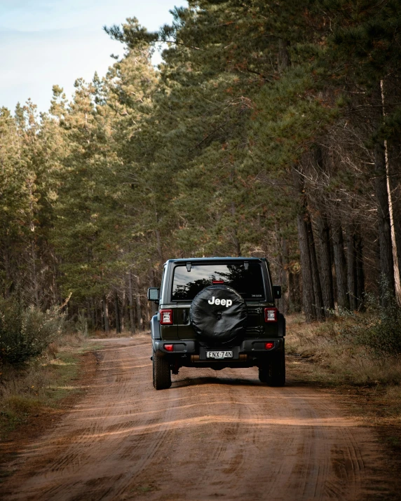 a black jeep that is parked on a dirt road