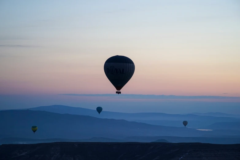 three  air balloons flying above a valley