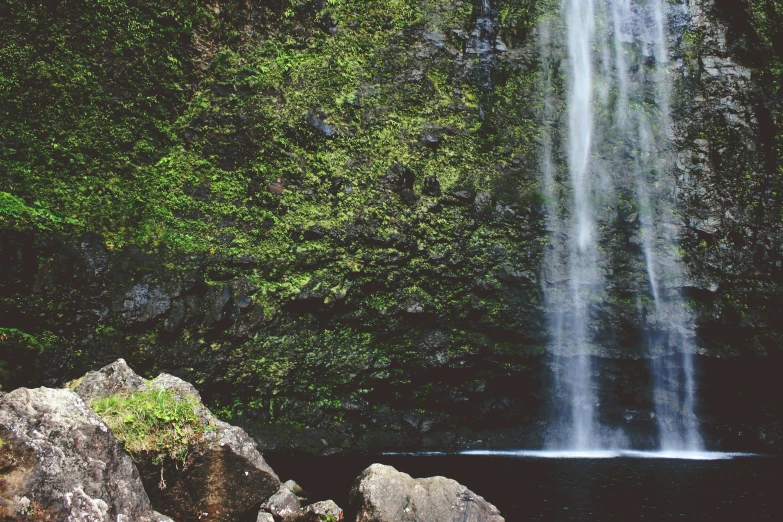 a large waterfall is shown with rocks and trees