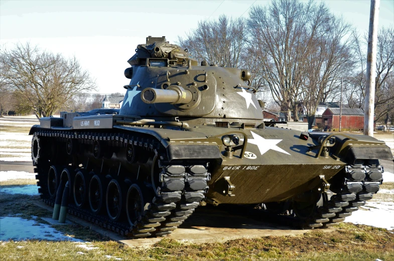 an army tank sitting on display next to a sidewalk