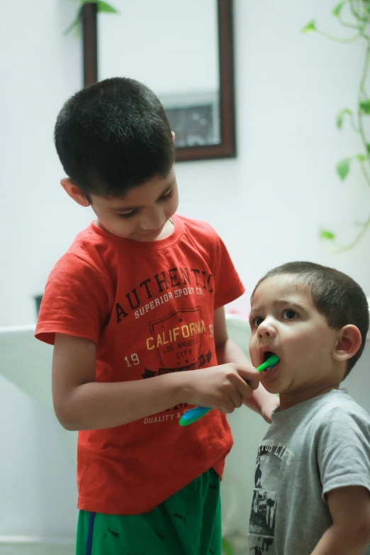 a  brushing his teeth while another child looks on