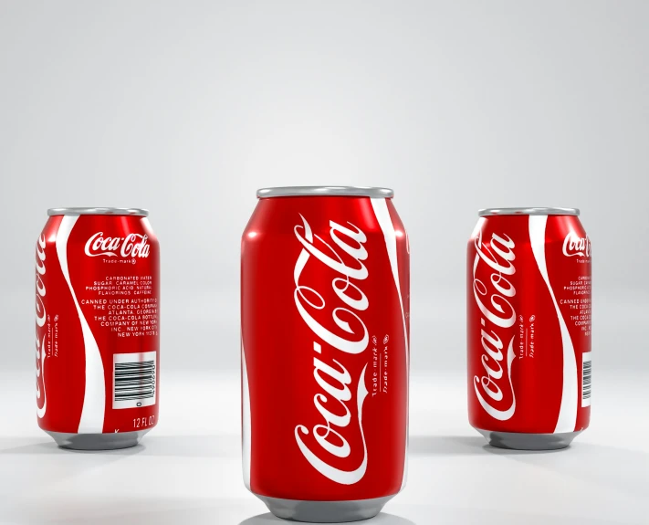 three cans of coca cola are sitting next to each other