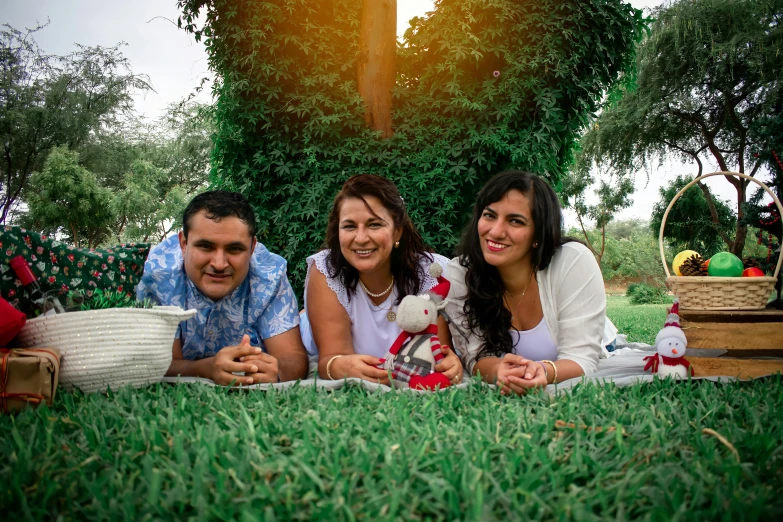 two couples lie on the grass at the end of their picnic