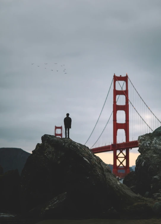 a person standing on the side of the golden gate bridge