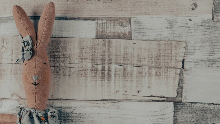 a small stuffed animal hanging on the side of a wood paneled wall