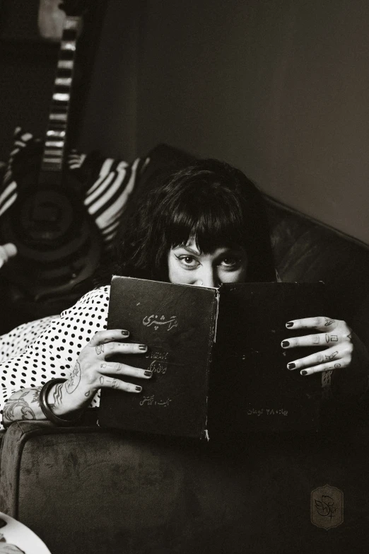 a person with a book is laying on a couch