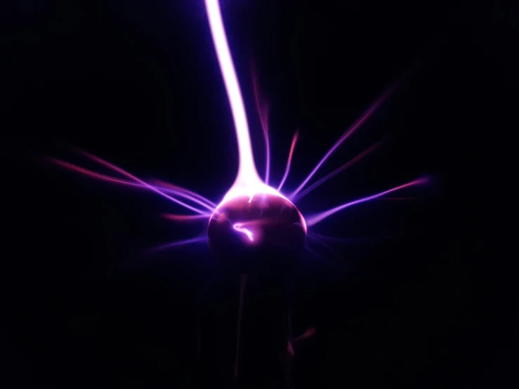 a dark background with a ball of light with multiple pink, blue and white streaks