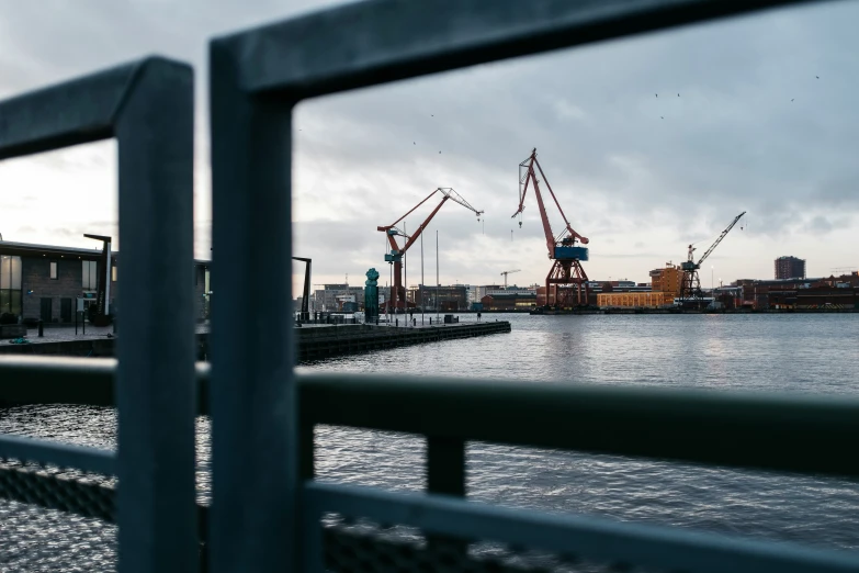 some cranes are seen in the distance along water