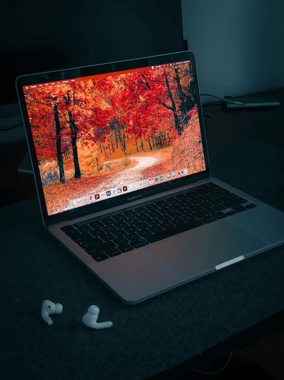 a laptop computer and ear buds on a table