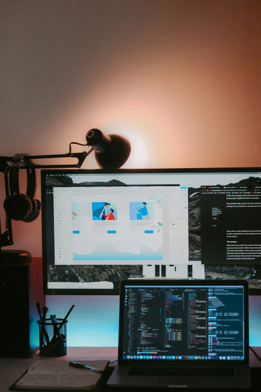 two computers are next to each other on the desk