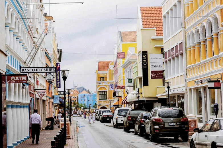 an urban street with yellow buildings and cars on it