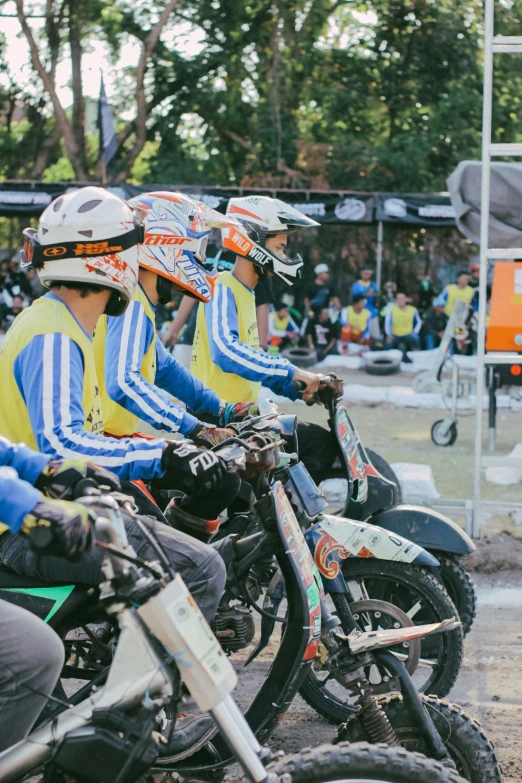 four guys sitting on motorcycles at an event