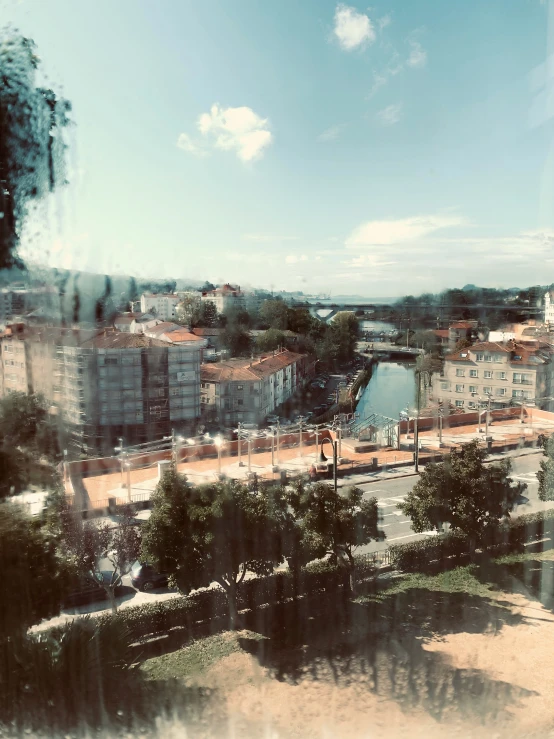 a po of buildings on a hillside, looking out a window