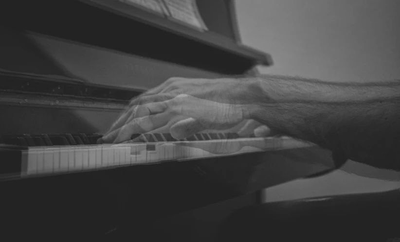 hands and feet using a piano in black and white