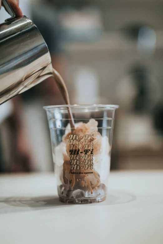 the coffee being poured into a glass cup