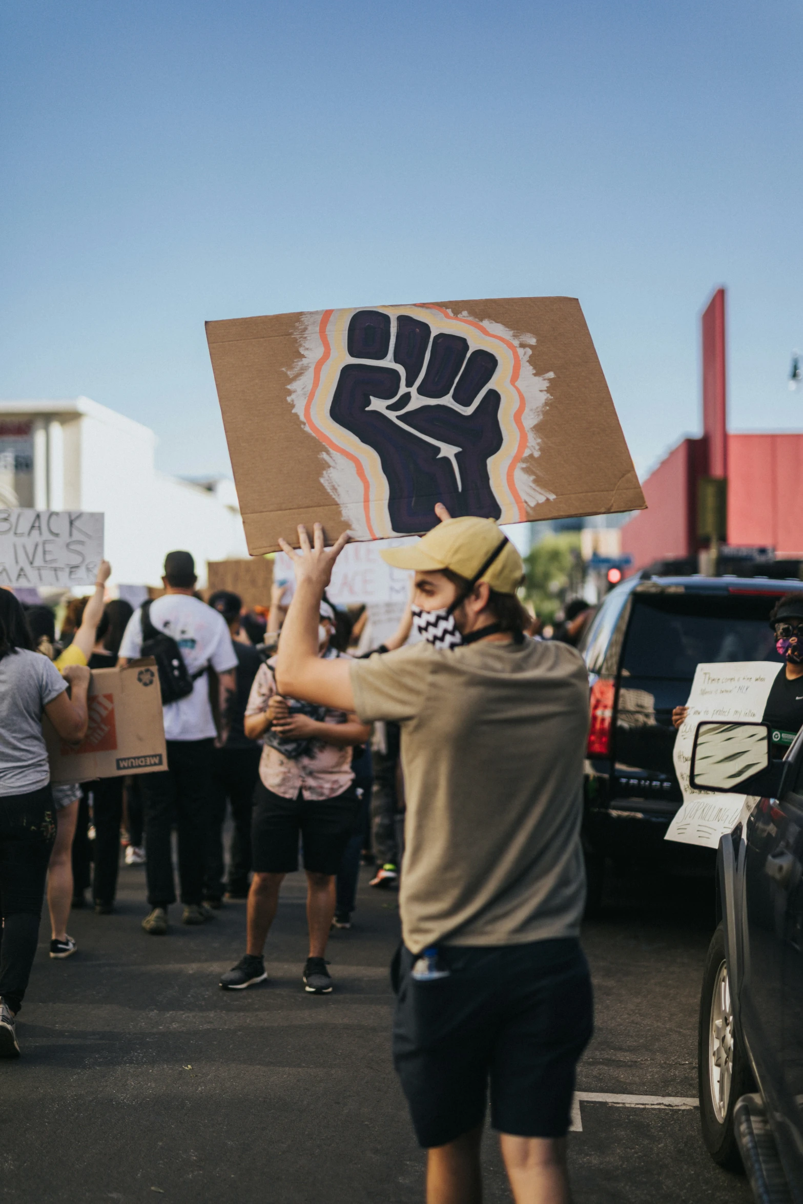 a man holding a sign near cars and buildings